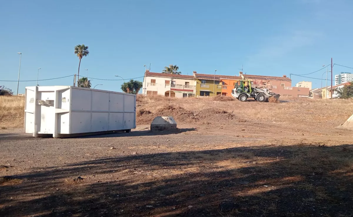 Una excavadora limpia un solar en el barrio de García Escámez donde los vecinos hacen todos los años la hoguera de San Juan./ CEDIDA