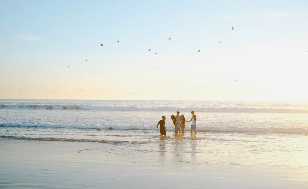 Imagen de un grupo de personas disfrutando de la playa / CANVA