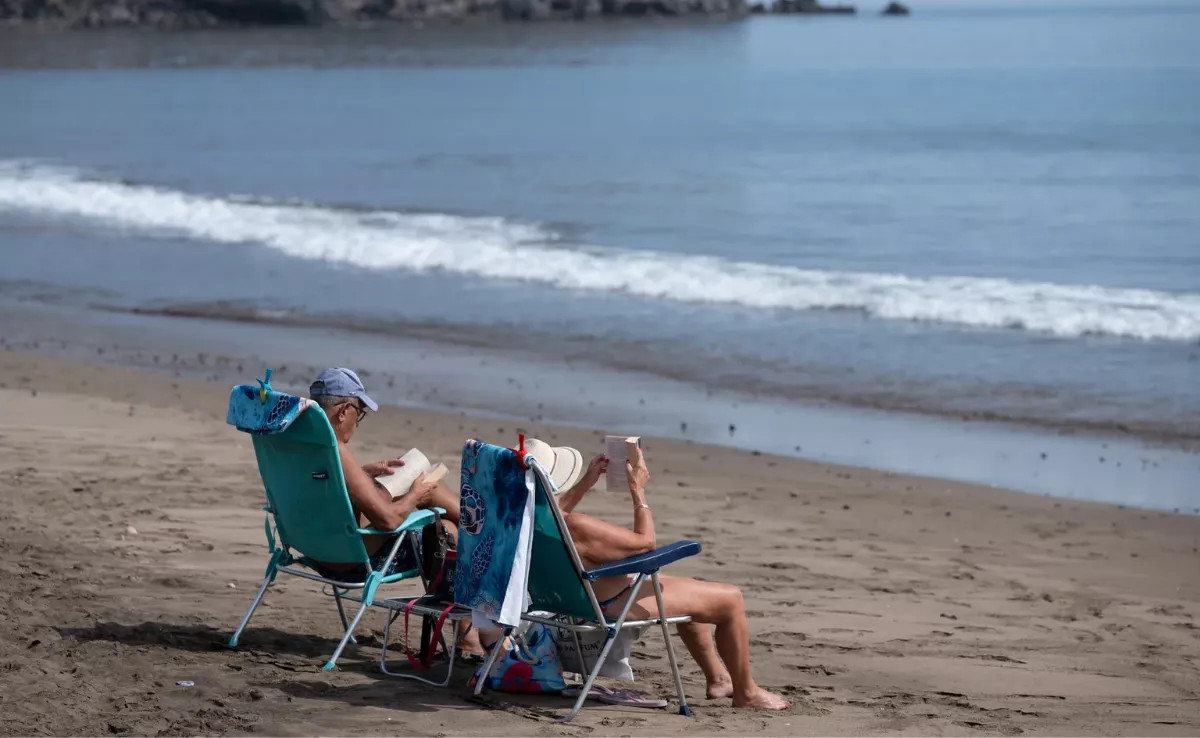 Imagen de dos personas en la playa / EFE