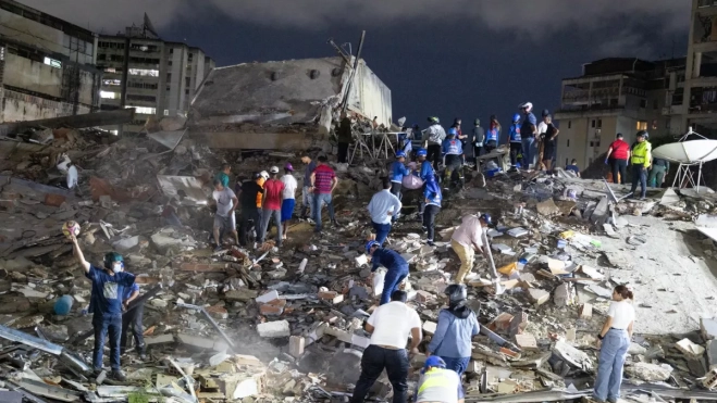 Imagen de varias personas frente a un edificio totalmente derruido tras el terremoto en Venezuela / EFE