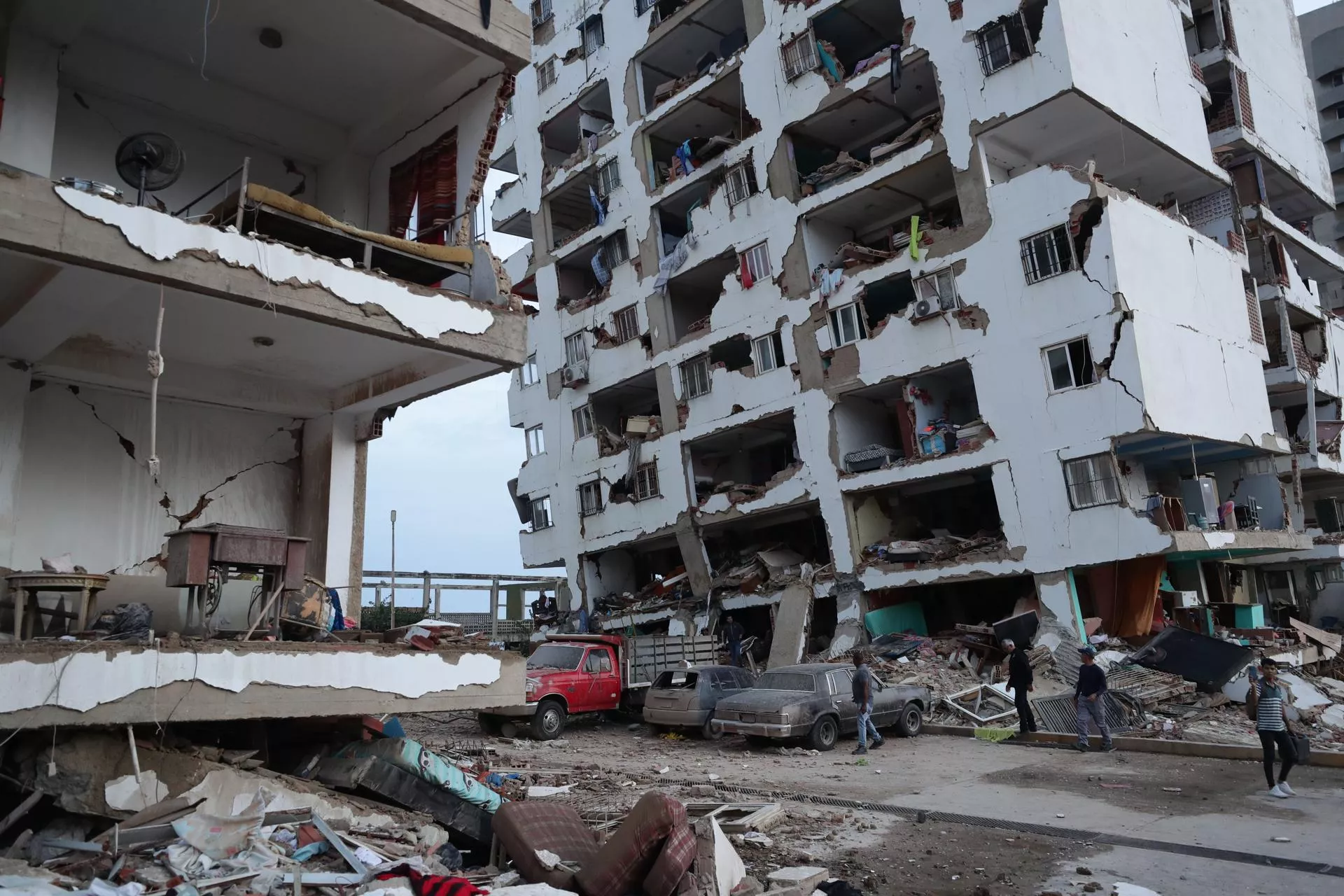 Residentes caminan entre los escombros de varios bloques de viviendas dañados por los terremotos en la localidad de Catia La Mar, en el estado costero de La Guaira (Venezuela) este jueves. / EFE- RONALD PENA R