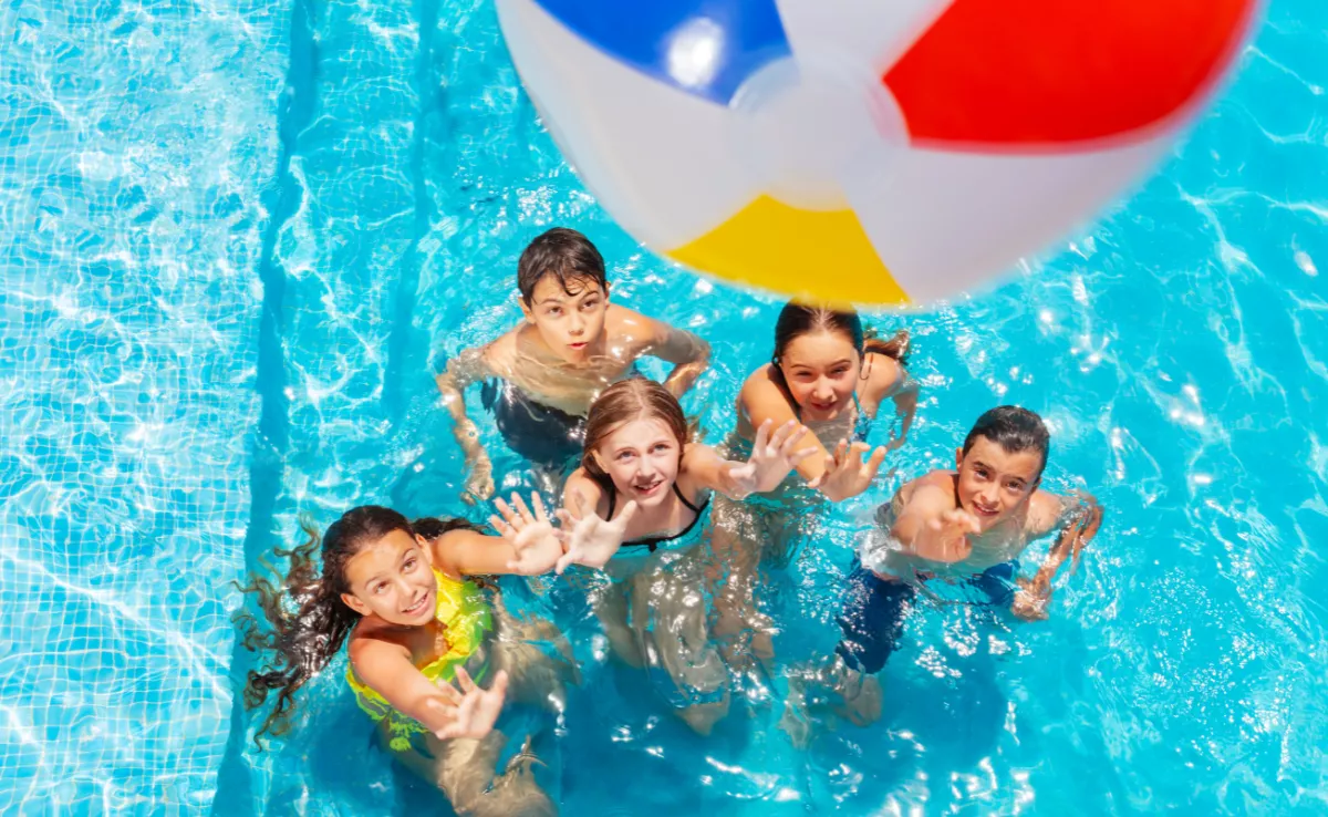 Imagen de unos niños jugando en la piscina / CANVA
