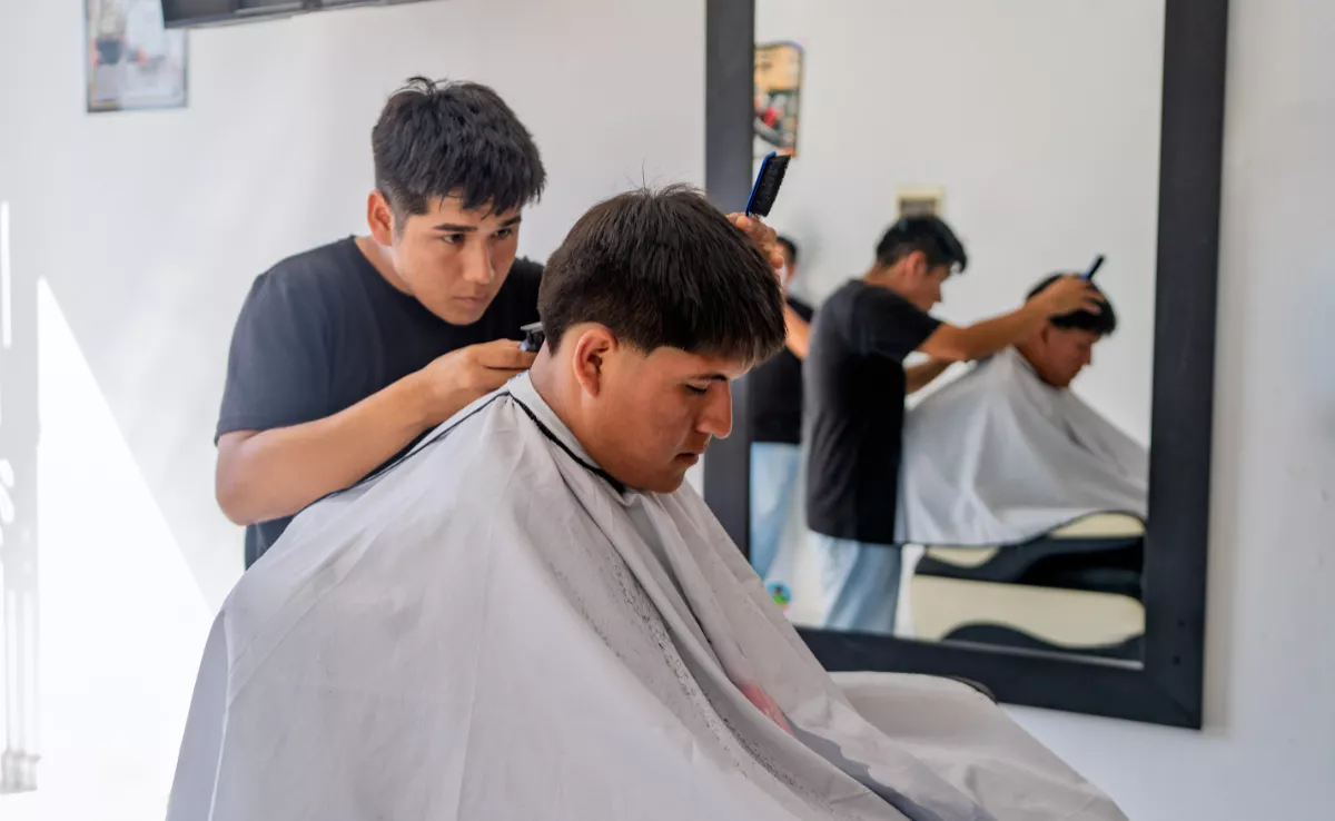 Una persona corte el pelo a otra en su barbería. IMAGEN DE LA RED