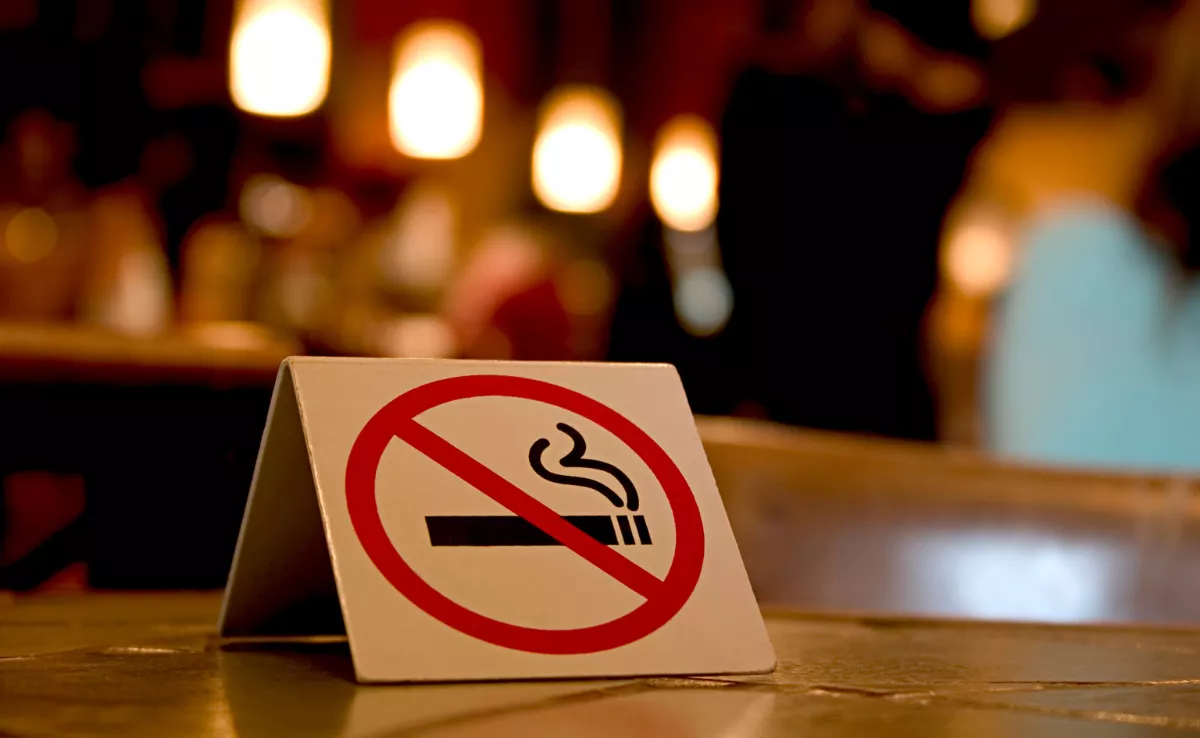 Imagen de un cartel que prohíbe fumar en una mesa de restaurante. / CANVA