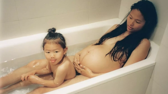 Una mujer embarazada junto a su hija en la bañera. / MATY CHEVRIÈRE 