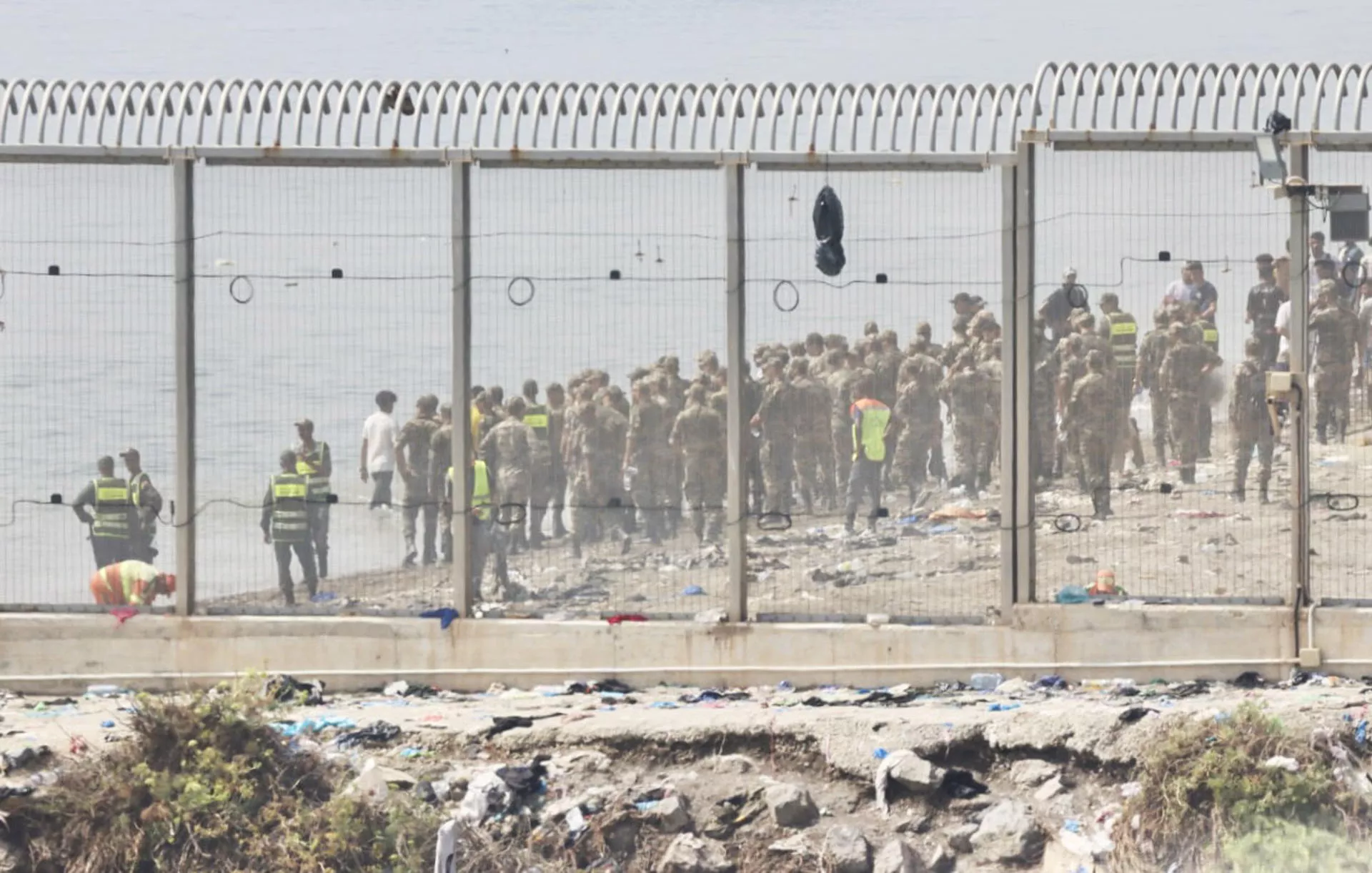 Fuerzas auxiliares de Marruecos impiden la llegada al espigón de la playa del Tarajal que separa Ceuta de Marruecos./ EFE/Reduan