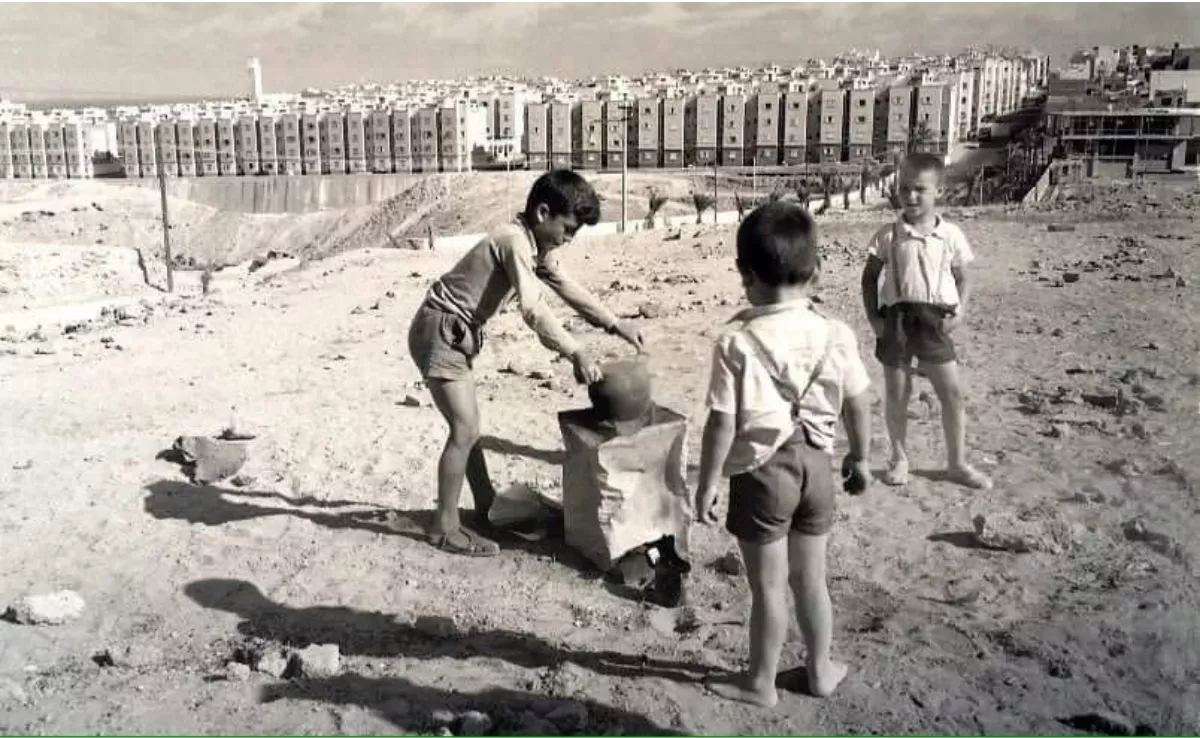 Unos niños juegan en un descampado de Escaleritas,  donde hoy se levantan las funestas torres del Canódromo. Al  fondo, Schamann, con su primera hilera de edificios en la calle Sor Simona. / FRANCISCO ROJAS FARIÑA (FACHICO)
