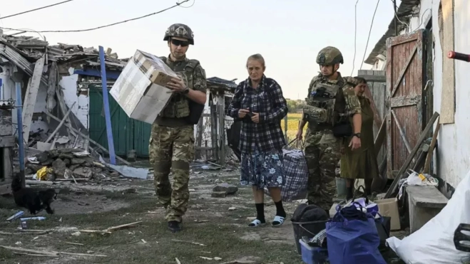 Policías ucranianos y voluntarios de la organización pública "Chaplain Patrol" evacúan a personas mayores de localidades situadas en la línea del frente en la región de Zaporiyia. EFE/EPA/Oleg Movchaniuk Policías ucranianos y voluntarios de la organización pública "Chaplain Patrol" evacúan a personas mayores de localidades situadas en la línea del frente en la región de Zaporiyia. EFE/EPA/Oleg Movchaniuk