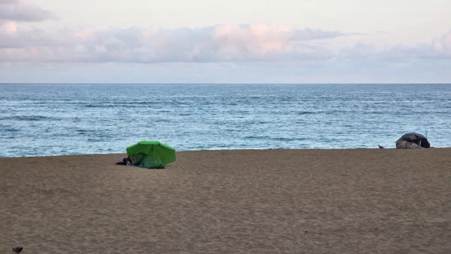 Dos personas durmiendo en la playa de Las Canteras. Dos personas durmiendo en la playa de Las Canteras.