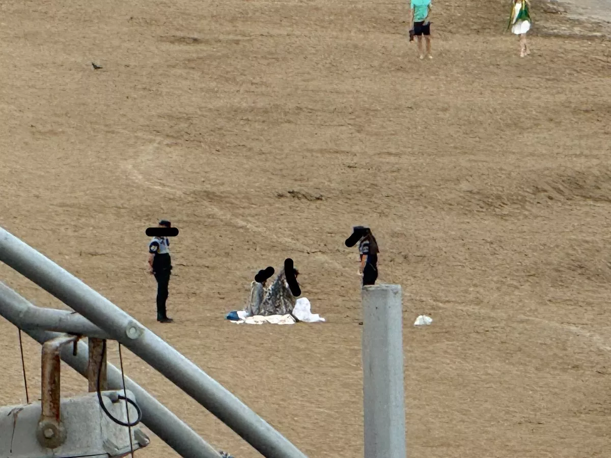 Agentes de la Policía Local de Las Palmas de Gran Canaria desalojan a una persona que pernoctaba en la playa este viernes a primera hora. MIPLAYADELASCANTERAS