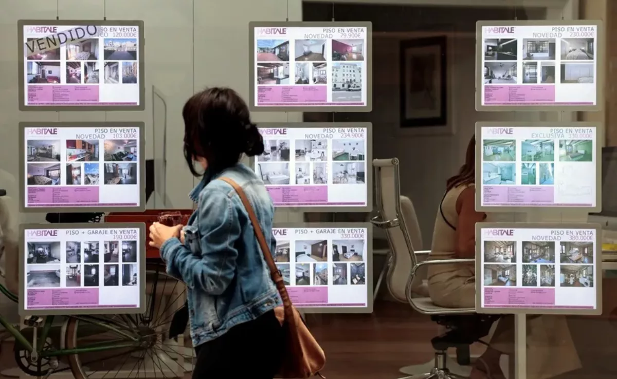 Imagen de una persona mirando carteles de viviendas en venta / EFE