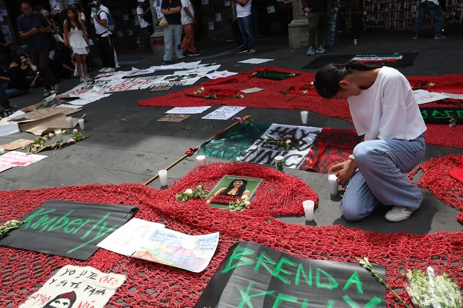 Una estudiante coloca ofrendas durante una protesta para exigir justicia por el asesinato de Claudia Tacoronte. / EFE - ALEX CRUZ