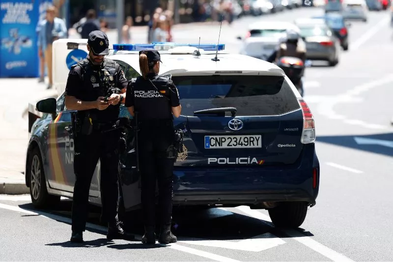 Una pareja de la Policía Nacional junto al coche patrulla. / EFE - MARISCAL 