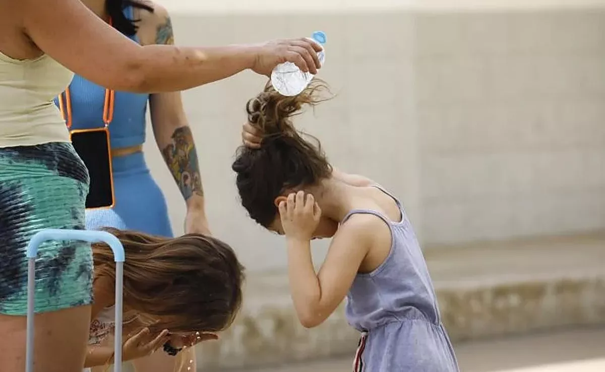 Unas alumnas se refrescan en plena ola de calor / EFE
