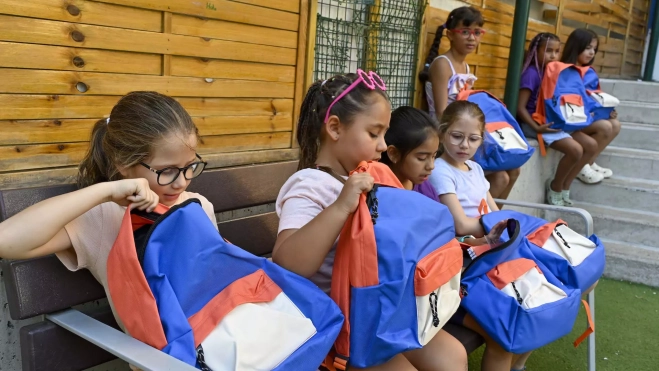 Un grupo de niñas examina las mochilas con material escolar que reciben a través del programa CaixaProinfancia de la Fundación "la Caixa" al comenzar el curso escolar Un grupo de niñas examina las mochilas con material escolar que reciben a través del programa CaixaProinfancia de la Fundación "la Caixa" al comenzar el curso escolar