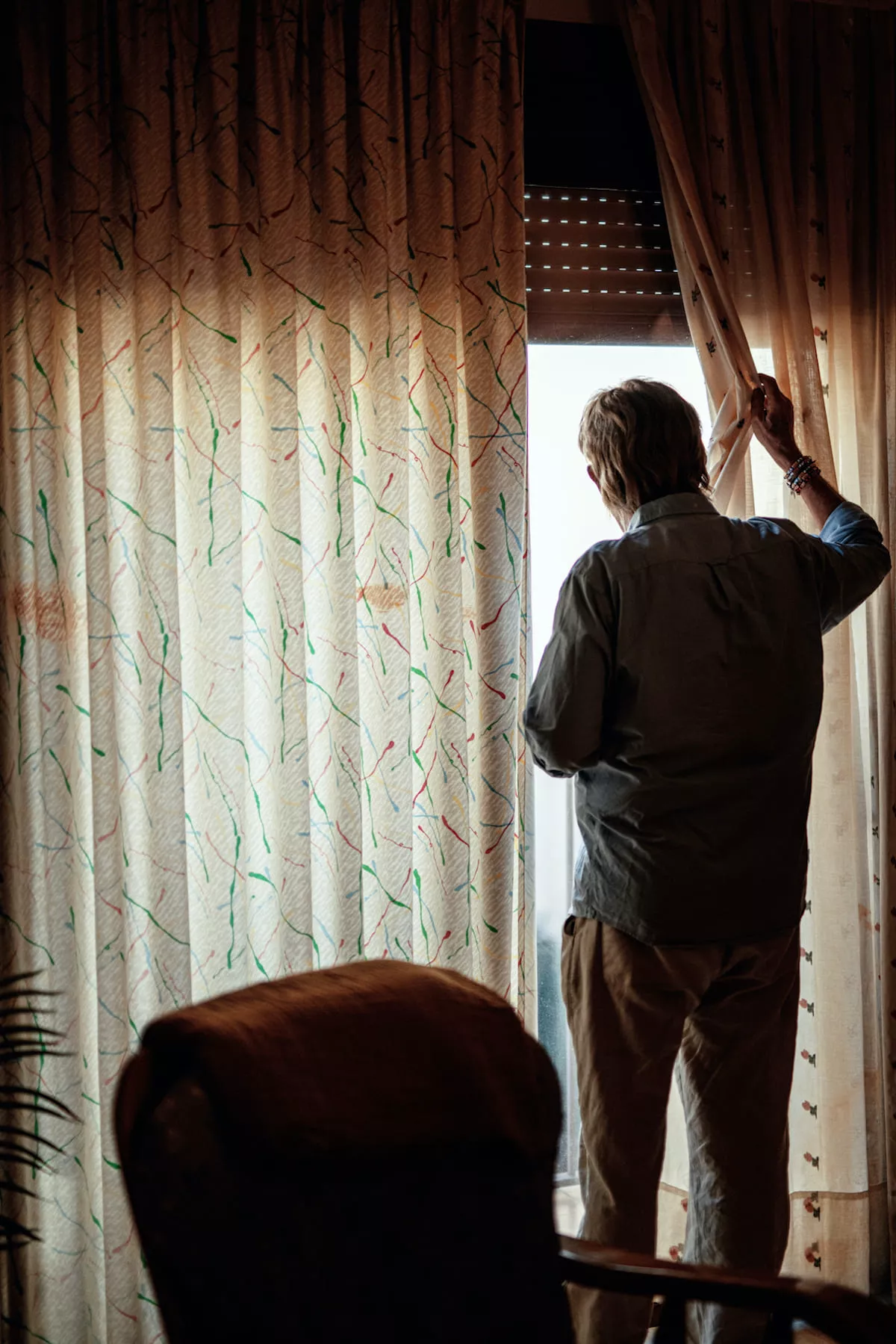 Un hombre mayor observa la calle desde su ventana / Fundación ”la Caixa”