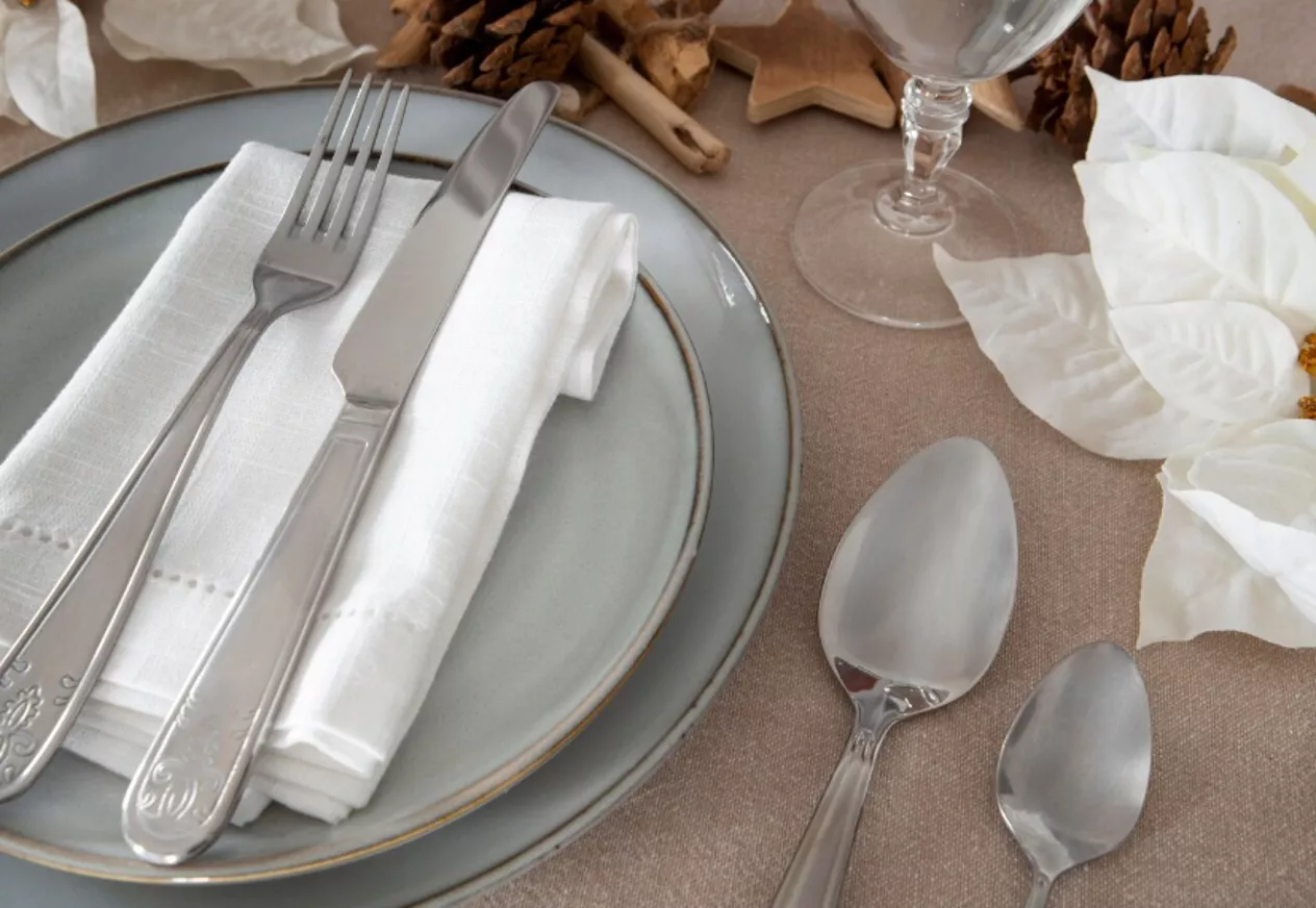 Cubiertos, cristalería y platos sobre un mantel