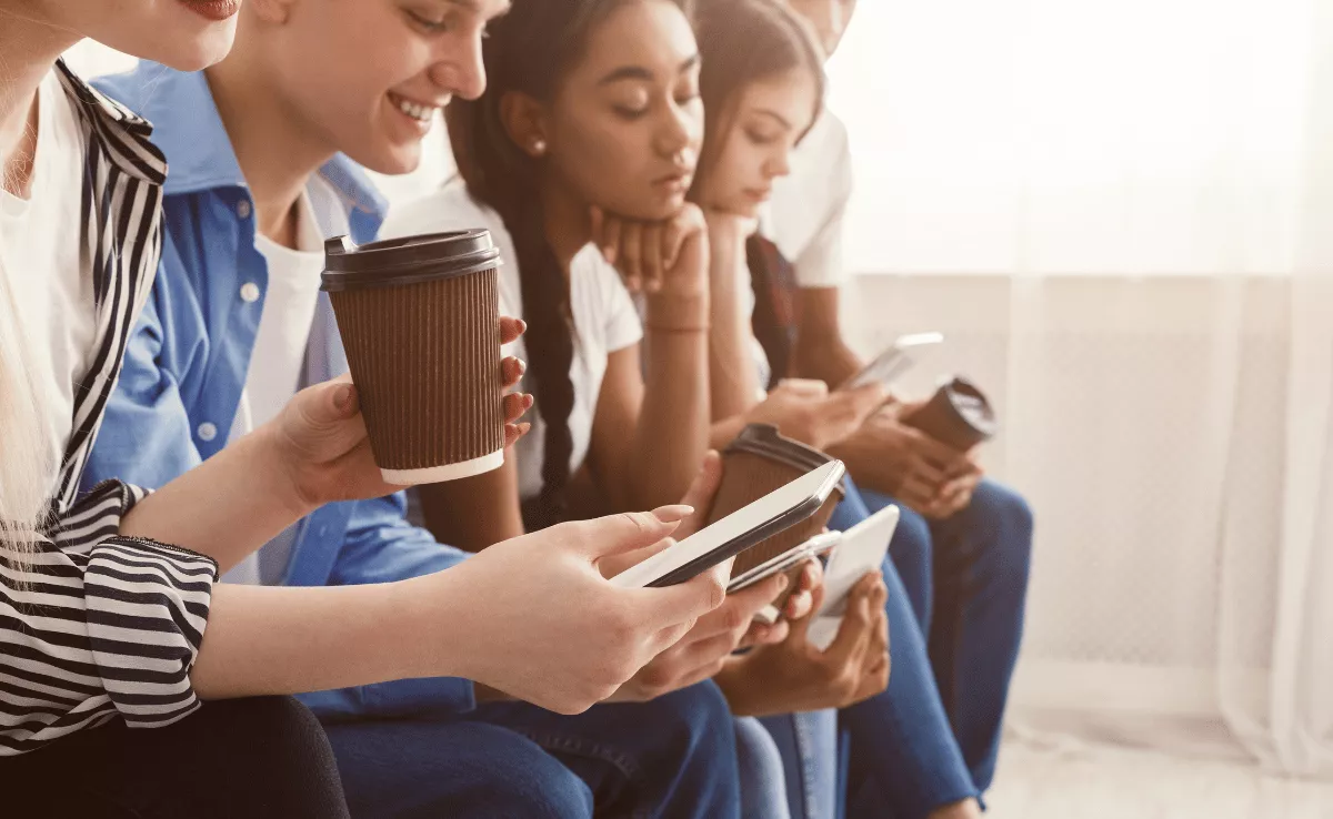 Imagen de unos jóvenes usando sus teléfonos móviles / CANVA