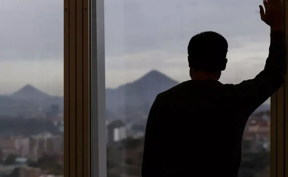 Un hombre mira por la ventana de su oficina en una imagen de archivo./ Miguel Toña (EFE)