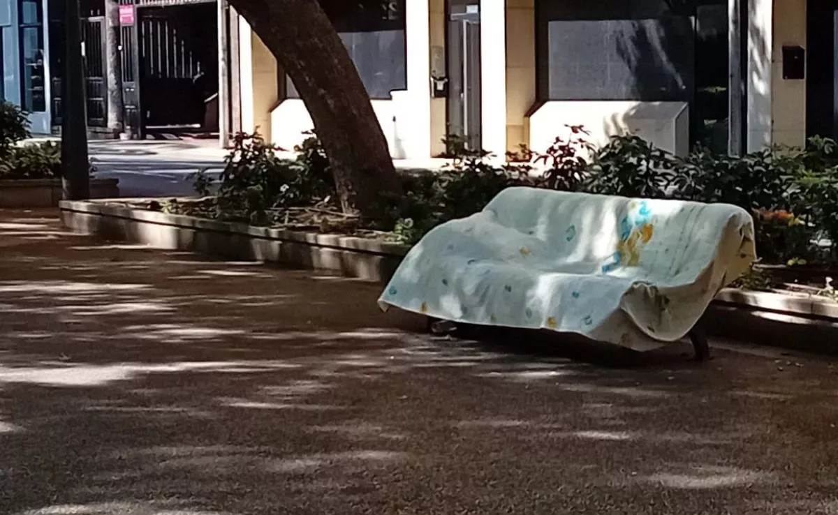 Mobiliario municipal convertido en la cama de una persona sin hogar en la Rambla de Santa Cruz|AH